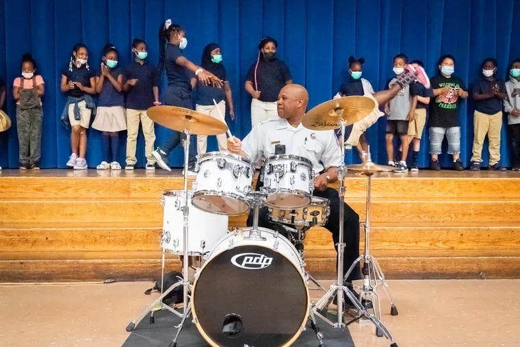 Philadelphia Police Lt. Jeff Campbell plays the drums as second grade students put on a concert at Hartranft Elementary School. When the music teacher quit at Hartranft Elementary in North Philadelphia, police stepped in so that the students would not have to go without.