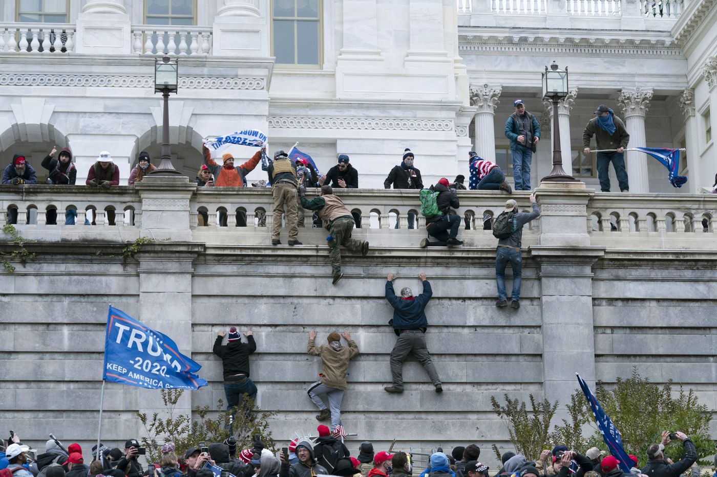 Supporters of President Donald Trump climb the west wall of the U.S. Capitol after overwhelming police during a riot on Wednesday, Jan. 6, 2021, in Washington, D.C.