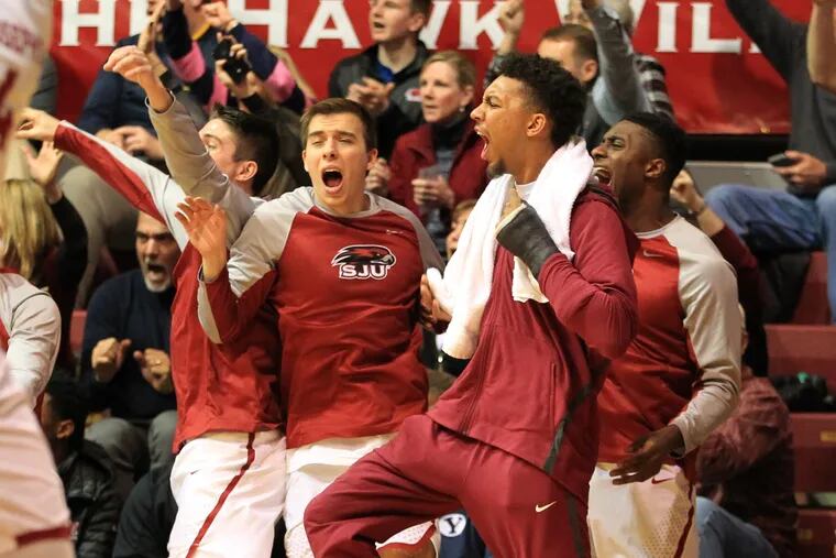 The St. Joseph's bench including injured star Charlie Brown celebrate after a Taylor Funk 3-point shot in the 2nd half against Duquesne at Hagan Arena on Feb. 17, 2018. CHARLES FOX / Staff Photographer