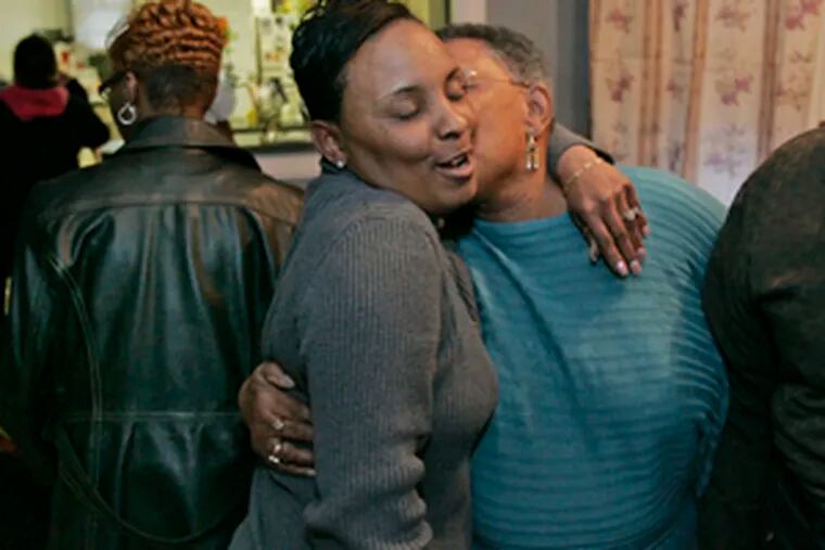 April Brown (center) gets a hug from her aunt Alice Werts. Brown&#0039;s fiance , Charles Baldwin, was killed when a stray bullet pierced his second-floor window as he was preparing for work.