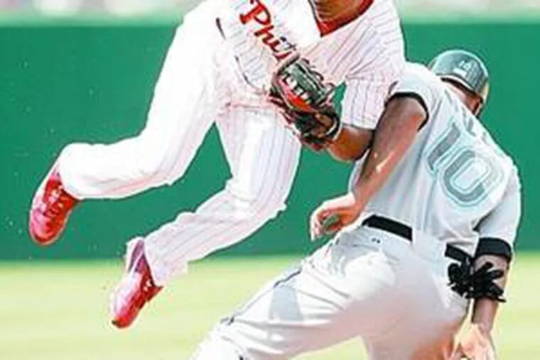 Phillies third baseman Abraham Nunez soars after tagging out Vernon Wells on steal attempt.