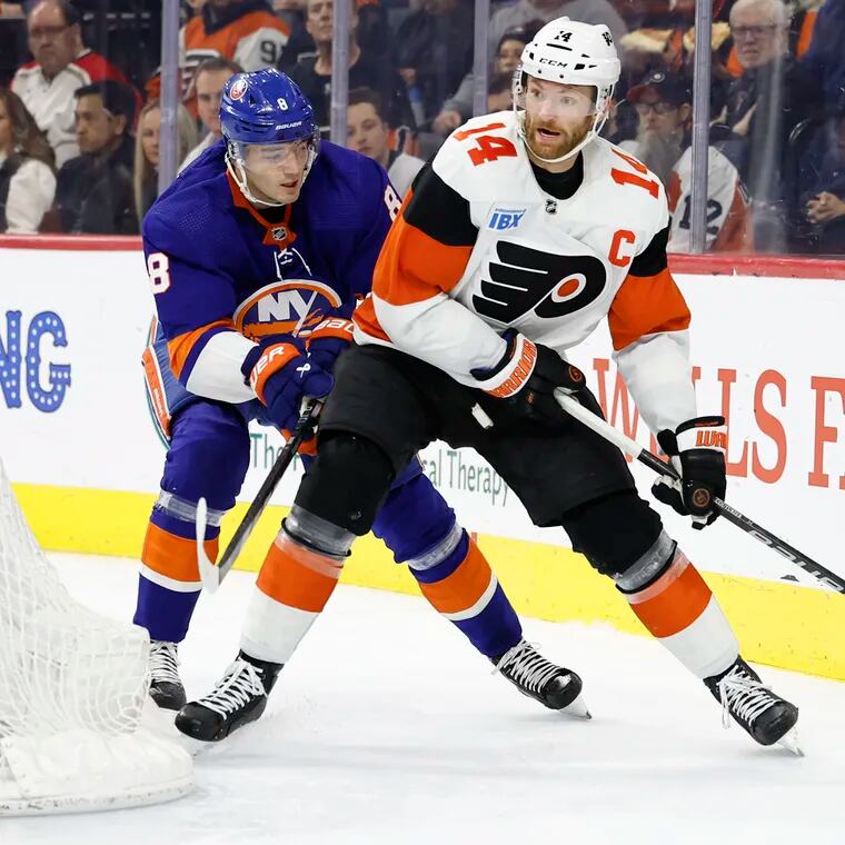 Flyers center Sean Couturier skates with the puck against New York Islanders defenseman Noah Dobson last Monday.  Couturier has 36 points (11 goals, 25 assists) in 70 games.