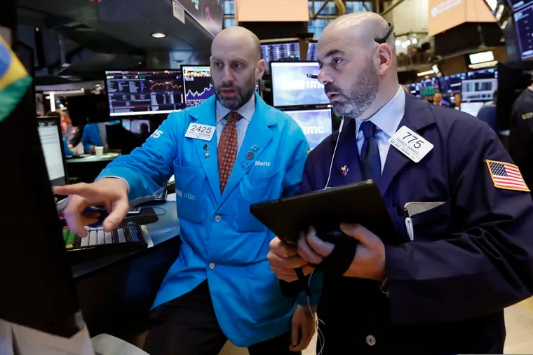 Specialist Meric Greenbaum, left, and trader Fred DeMarco work on the floor of the New York Stock Exchange.