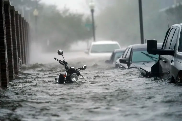 Cars and a motorcycle were underwater as Hurricane Sally flooded a street Wednesday in Pensacola, Fla.