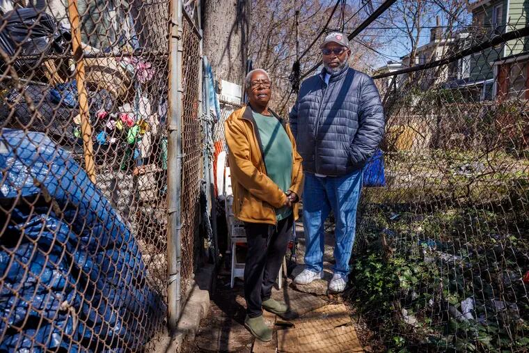 Lorraine Falligan and Aaron Sanders want help cleaning up a nuisance house in the 3000 block of North Sydenham Street in North Philadelphia. To their left is the backyard of the problem house, which is filled with trash.