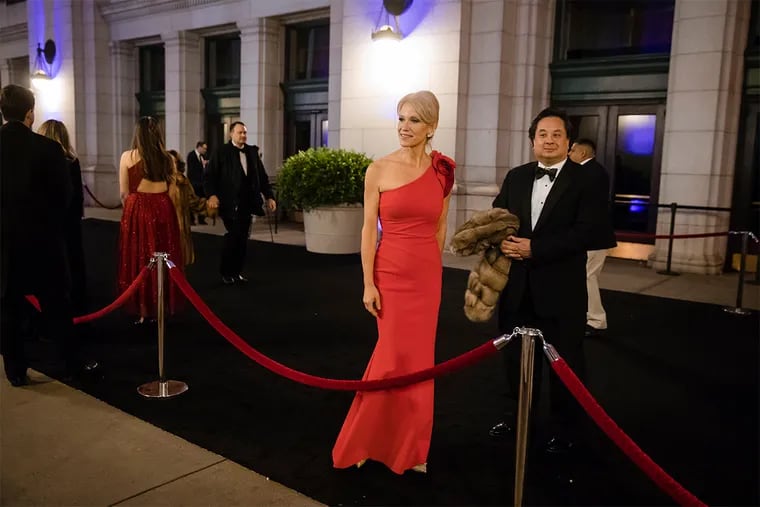 In this Thursday, Jan. 19, 2017 photo, President-elect Donald Trump adviser Kellyanne Conway, center, accompanied by her husband, George, speaks with members of the media as they arrive for a dinner at Union Station in Washington, the day before Trump's inauguration.