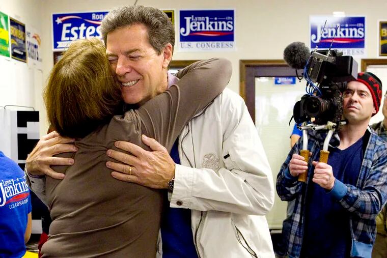 Republican Gov. Sam Brownback getting a hug from Carol Bainum during a visit to the Kansas Republican headquarters in Topeka on Election Day. He held on for a narrow victory.