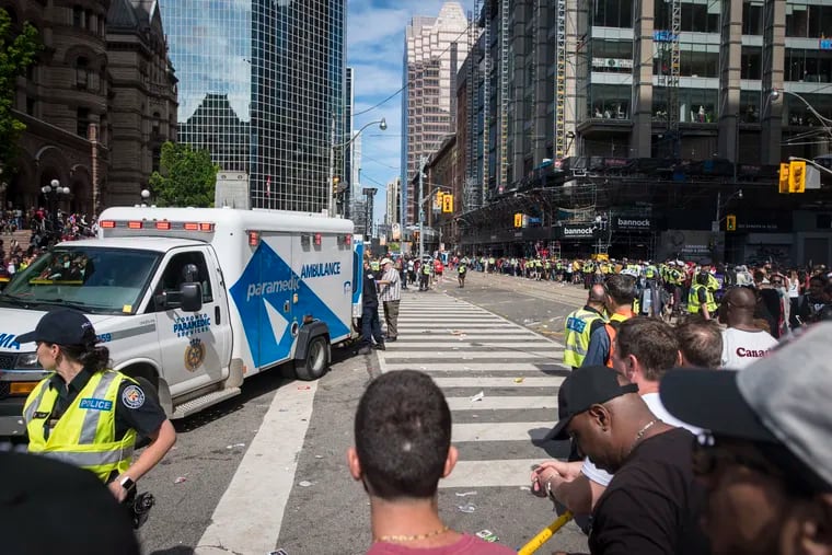 An ambulance arrives to the scene after shots were fired during the Toronto Raptors NBA basketball championship victory celebration near Nathan Phillips Square in Toronto, Monday, June 17, 2019. (Tijana Martin / The Canadian Press via AP)