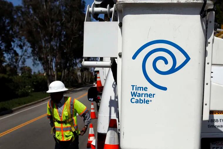 A Time Warner Cable technician checks a WiFi hot spot in Calif. Comcast's deal to acquire Time Warner Cable faces regulatory scrutiny.
