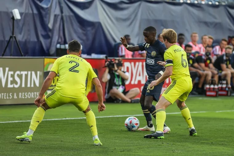 Union midfielder Jamiro Monteiro (center) tries to keep the ball from Nashville SC's Dax McCarty (right) and Daniel Lovitz (left) during the first half.