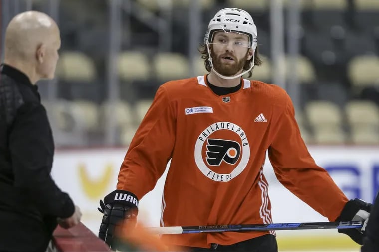Flyers center Sean Couturier talks with Jim McCrossin, the Flyers’ director of sports medicine during a morning skate Friday in Pittsburgh.