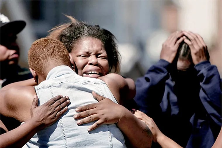 Teenamarie Shaw, who fled the fire and lost her home, weeps as she gets a hug Saturday, July 5, 2104. Her husband Maurice Anderson is on right. She said "this is my castle...I want my house back".