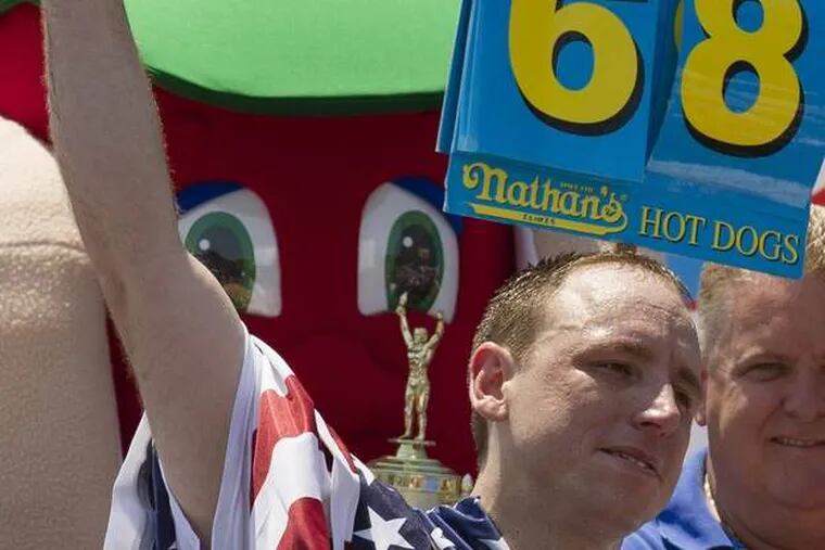 Five-time reigning champion Joey Chestnut celebrates after he wins his sixth Nathan&#039;s Famous Hot Dog Eating World Championship with a total of 68 hot dogs and buns, Wednesday, July 4, 2012, at Coney Island, in the Brooklyn borough of New York. (AP Photo/John Minchillo)
