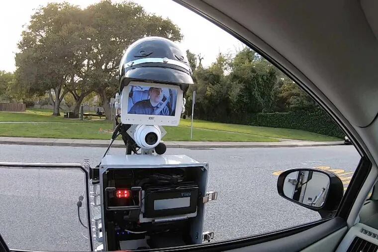 The GoBetween robot extends out from the police vehicle to the car that has been pulled over. When the encounter is done, the entire contraption retracts and the robot returns to the police car. (Handout photo courtesy of SRI International)