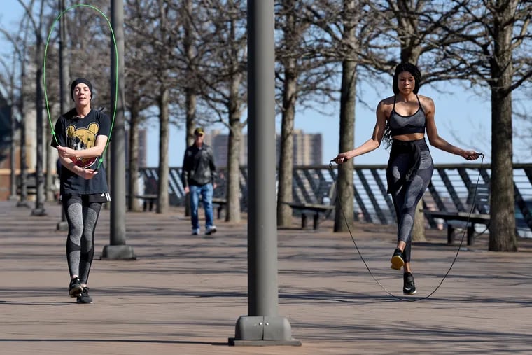 Despite the commands for social distancing, city dwellers still want to be out in the world, and people are out along the Race Street Pier near the Ben Franklin Bridge Mar. 15, 2020. Kacey Morrissey (left), 30, of South Philadelphia and Colette McDermott (right), 28, of Manayunk, work out with jump ropes. They both agreed that the space on the pier was open enough that they were not concerned about social distancing,