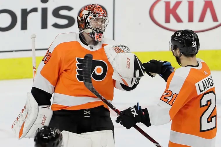 Flyers goalie Carter Hart is greeted by teammate Scott Laughton after his shutout victory over the Devils.