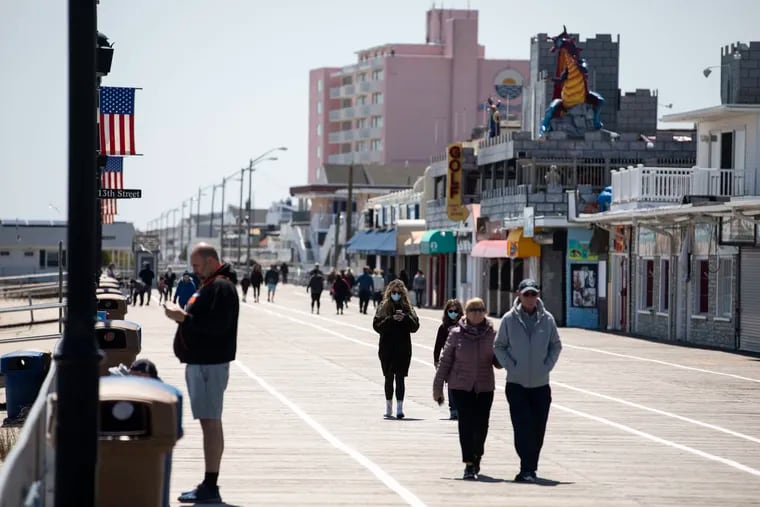 People walked down the boardwalk in Ocean City, N.J. on Sunday, May 10, 2020. The beaches and boardwalk in Ocean City were shut down in March to slow the spread of the coronavirus. They reopened this weekend for exercise and activities like surfing and fishing. Sunbathing, sitting in chairs, congregating in groups, playing group sports, and bathing are still prohibited.