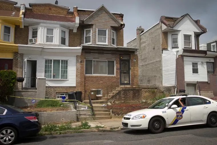 Philadelphia 35th District patrol car sits in front of 4846 N. 9th St. ( white row house) at left after children were allegedly removed after police found the home to be unsanitary. Photograph from Thursday morning August 8, 2013. ( ALEJANDRO A. ALVAREZ / STAFF PHOTOGRAPHER )