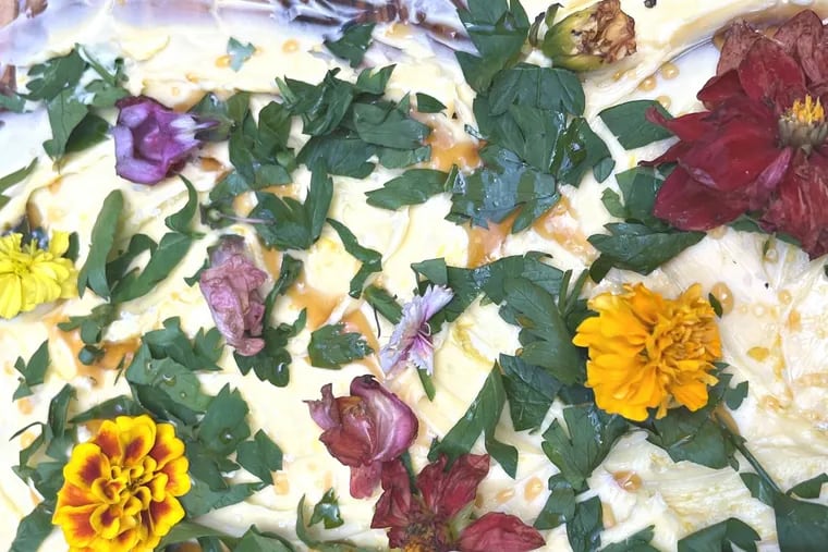 A butter board made by Inquirer Newsletter strategist Ashley Hoffman featuring Vermont butter, flaky Maldon salt, Mike's Hot Honey, and edible flowers served with toasted bread.