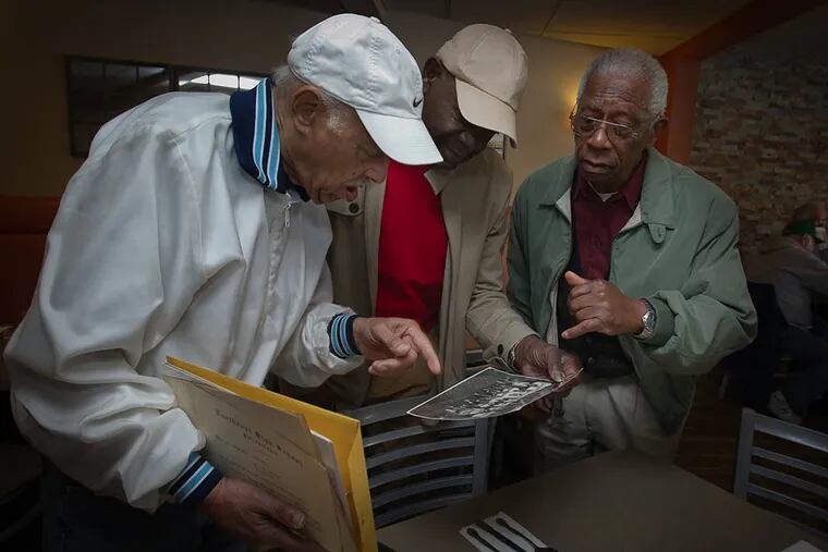 (From left) Henry Smyrl, George Logan, and Willie Moffit look at a picture of the Northeast High crosscountry team. (ALEJANDRO A. ALVAREZ/Staff Photographer)