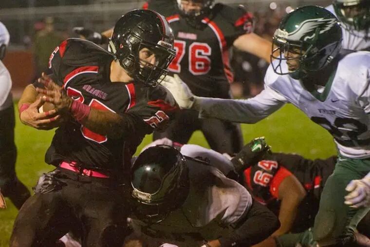 Kingsway's Anthony Seas (center, 25) runs the ball as Winslow Township's Khan Clark (right, 22) tries to make the tackle during Friday night's game at Kingsway High School in Woolwich, NJ.