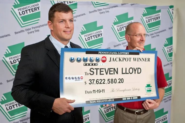 Steven Lloyd (right) of Harding, Luzerne County, Pa., holds a ceremonial check for his $37.6 million cash jackpot win in Powerball with Pennsylvania Lottery executive director Todd Rucci on Nov. 28. 2011.