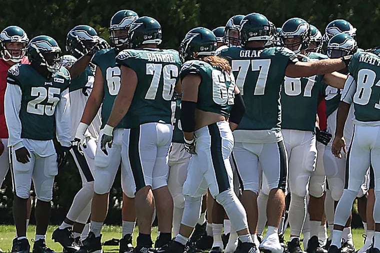 Eagles players huddle before practice. (David Maialetti/Staff Photographer)