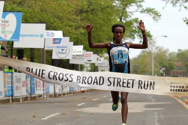 The winner of the women's Broad St. Run. Askale Merachi, crosses the finish line at the Navy Yard in South Philadelphia on Sunday, May 5, 2013.  ( Yong Kim / Staff Photographer )