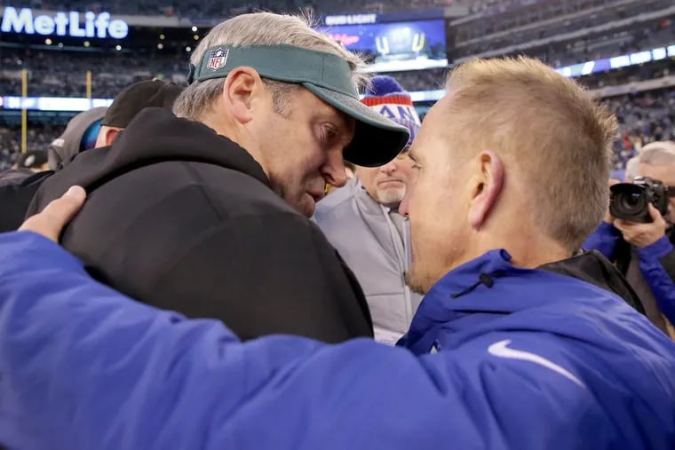Eagles head coach Doug Pederson, left, and Giants interim head coach Steve Spagnuolo, right, meet on the field after the Philadelphia Eagles win 34-29 over the New York Giants in East Rutherford, New Jersey on December 17, 2017.