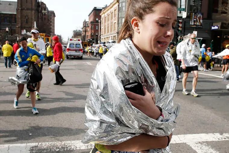 As marathon participants and spectators wander about the finish area, a runner leaves the course in tears. Another runner said the sound of the blasts was followed by confusion. WINSLOW TOWNSON / Associated Press