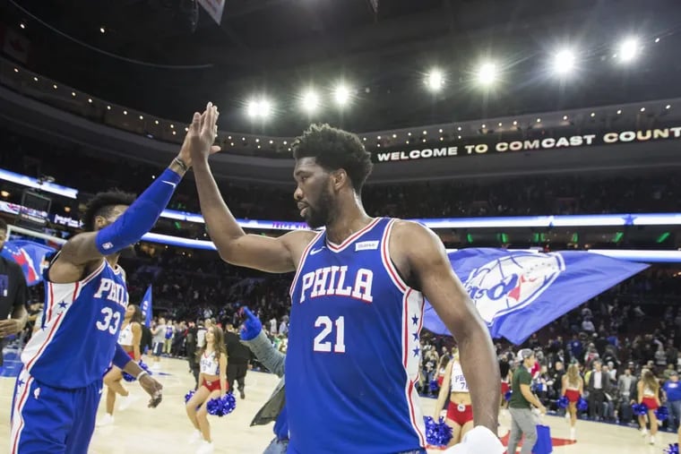 Robet Covington, left, and  Joel Embiid of the Sixers high-five after the Sixers defeated the Wizards 115-102 at the Wells Fargo Center on Feb. 6, 2018.