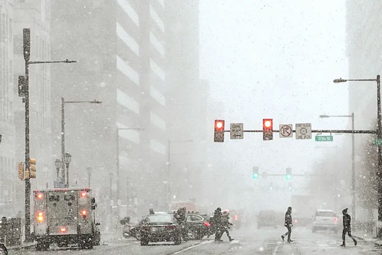 Pedestrians cross at 17th and JFK Boulevard during a snow squall on Jan. 8, 2020, during an otherwise snow-starved winter.