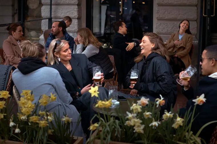 People chat and drink outside a bar in Stockholm, Sweden. Sweden is pursuing relatively liberal policies to fight the coronavirus pandemic, even though there has been a sharp spike in deaths.