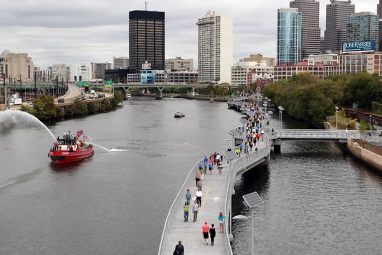 Pedestrians walking on the new Schuylkill Banks Boardwalk stop to enjoy the view during the inaugural opening of the boardwalk on Thursday, Oct. 2, 2014. ( MICHAEL BRYANT / Staff Photographer )