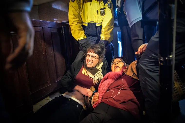 Police officers drag undocumented immigrant Carmen Guerrero and activist Nicole Kligerman from the entrance to City Hall during a rally Dec. 11, 2015.