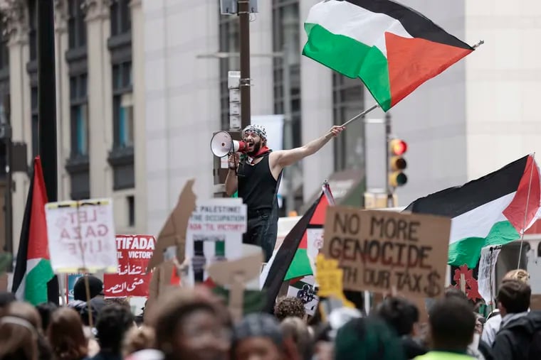 Qais Dana of Philadelphia gets people chanting “Palestine will be free” during a rally and march at City Hall.