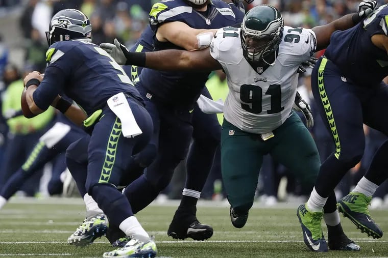Eagles’ Fletcher Cox, right, reaches for Seahawks’ quarterback Russell Wilson, left, during the 1st quarter. Philadelphia Eagles lose 26-15 to the Seattle Seahawks in Seattle, WA on November 20, 2016. DAVID MAIALETTI / Staff Photographer