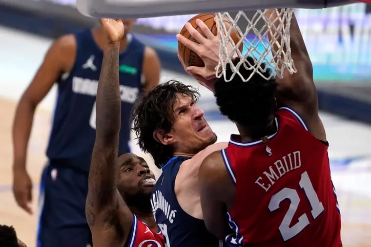 Sixers guard Shake Milton, left, and center Joel Embiid defend as Dallas Mavericks center Boban Marjanovic works to take a shot in the first half.