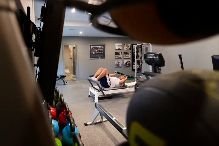 Garrett Miller works out in his home gym in West Mount Airy. He and his wife, Jennifer, purposefully designed a basement with high ceilings in their new house to accommodate a gym.