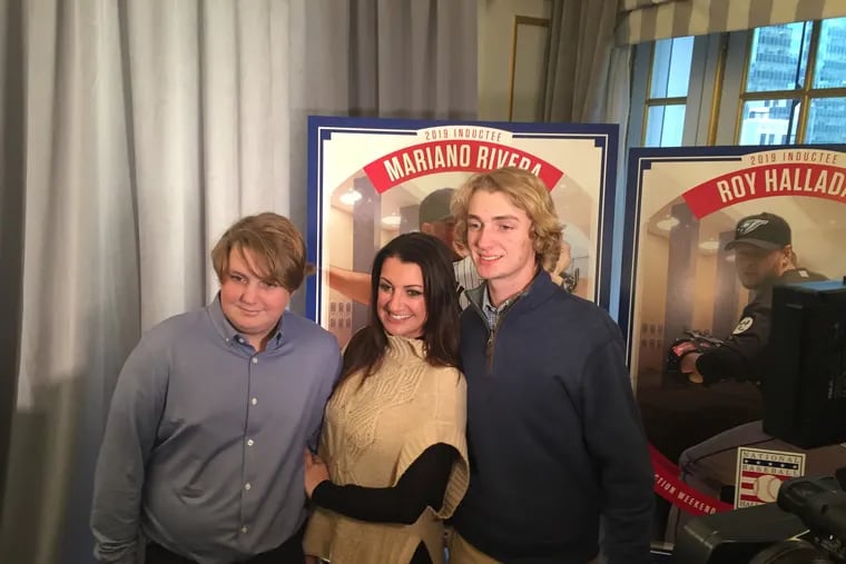 Brandy Halladay with her two sons , Ryan (left) and Braden next to Roy Halladay Hall of Fame poster in New York on Jan. 23, 2019