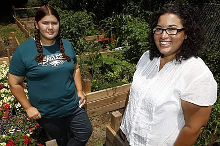 Aine (left) and Emaleigh Doley encouraged neighbors to revitalize their block of West Rockland Street in Germantown by becoming urban gardeners in their own yards. The sisters' "Grow This Block!" campaign led West Rockland to receive the Streets Department's Philadelphia More Beautiful Neighborhood Transformation Award last year. Alejandro A. Alvarez / Staff Photographer