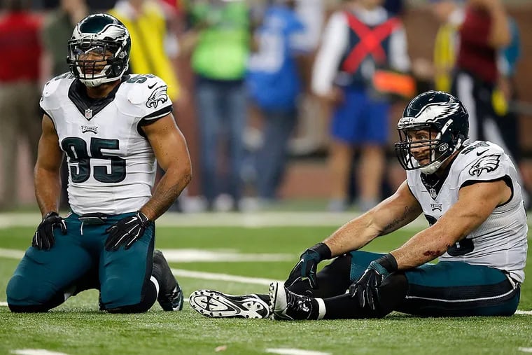 Mychal Kendricks and Connor Barwin sit on the turf after the Lions' Golden Tate scored a touchdown.