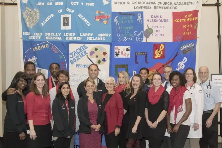 Jody Borgman and his team in front of an AIDS quilt last December.