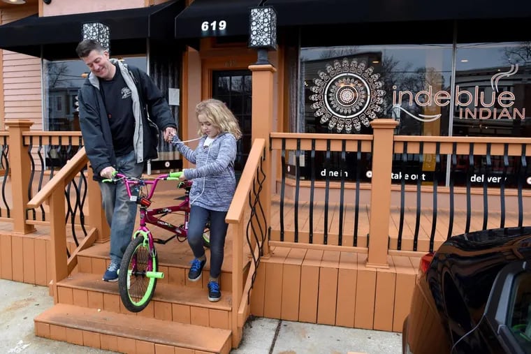 Brian Smith and his daughter Kamiryn, 9, leave indeblue after dinner in Collingswood Monday, in advance of its closing this Friday. The Philadelphia location will remain open.