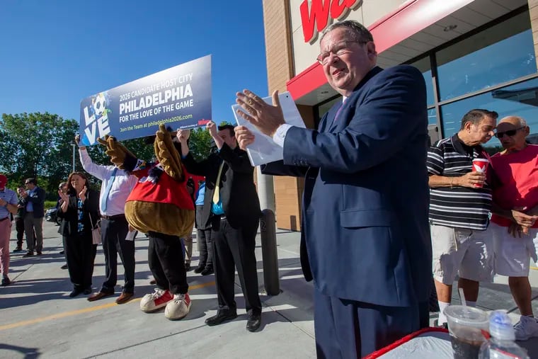 Philadelphia's 2026 World Cup bid chief David L. Cohen applauds as Wawa's mascot joins in the celebrations of the company joining the campaign.