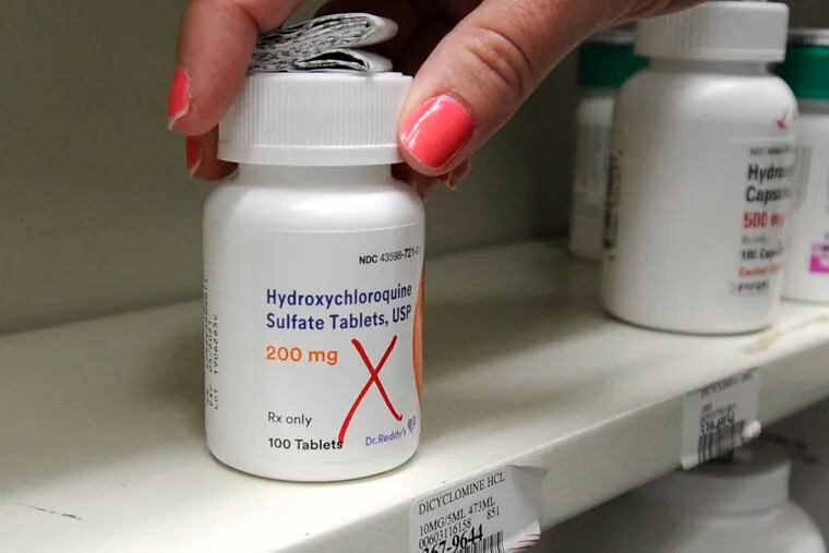 In this March 31, 2020 file photo pharmacist Amanda Frank reaches for a bottle of Hydroxychloroquine at the Medicine Shoppe in Wilkes-Barre, Pa. Some politicians and doctors are sparring over whether to use hydroxychloroquine against the new coronavirus, with many of scientists saying the evidence is too thin to recommend it now.  (Mark Moran/The Citizens' Voice via AP, file)