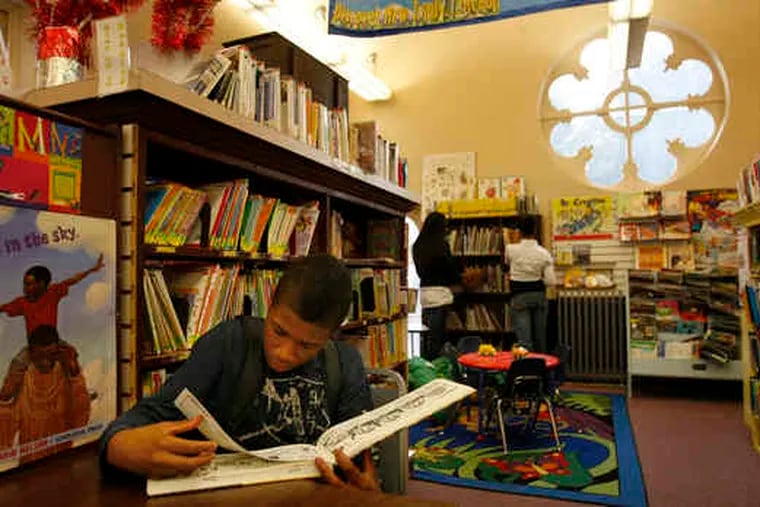 Dequon Townend, 13, above, reads a book at the Darby Free Library. The library is housed in a building at 10th and Main Streets, left, that was built in 1872. A cut in state funding has left the library $30,000 short this year.
