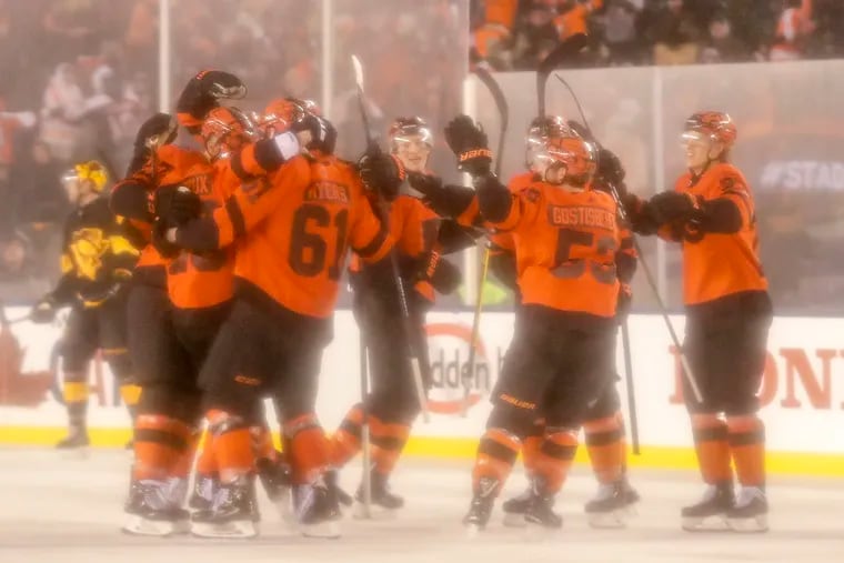 The Flyers celebrate center Claude Giroux's overtime goal Saturday, beating the Pittsburgh Penguins 4-3 in the Stadium Series game at Lincoln Financial Field.