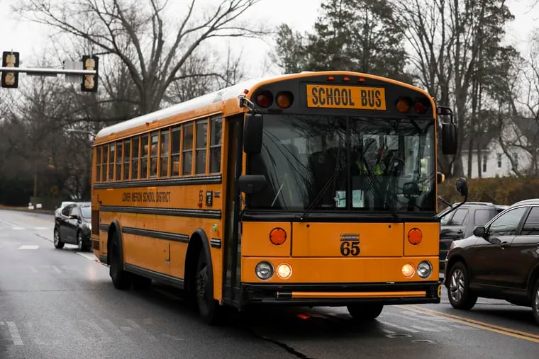 Buses leave Lower Merion High School in Ardmore in December 2020.