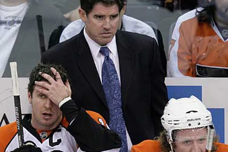 Flyers coach Peter Laviolette stands behind Mike Richards, left, and Scott Hartnell during the second period against the Penguins. (AP Photo / Gene J. Puskar)